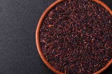 Seramik bir kasede kırmızı veya kahverengi çiğ pirinç. Pirinç Asya organik gıdasının bir malzemesidir.