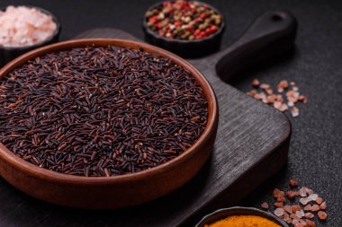 Seramik bir kasede kırmızı veya kahverengi çiğ pirinç. Pirinç Asya organik gıdasının bir malzemesidir.