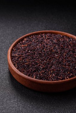 Seramik bir kasede kırmızı veya kahverengi çiğ pirinç. Pirinç Asya organik gıdasının bir malzemesidir.