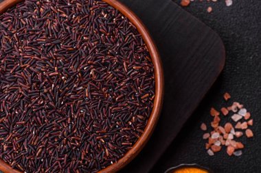 Seramik bir kasede kırmızı veya kahverengi çiğ pirinç. Pirinç Asya organik gıdasının bir malzemesidir.