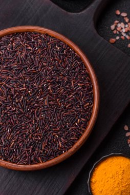 Seramik bir kasede kırmızı veya kahverengi çiğ pirinç. Pirinç Asya organik gıdasının bir malzemesidir.