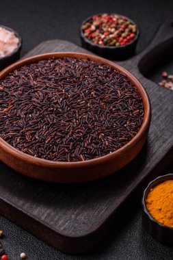 Seramik bir kasede kırmızı veya kahverengi çiğ pirinç. Pirinç Asya organik gıdasının bir malzemesidir.