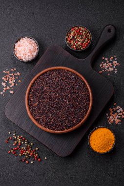 Seramik bir kasede kırmızı veya kahverengi çiğ pirinç. Pirinç Asya organik gıdasının bir malzemesidir.