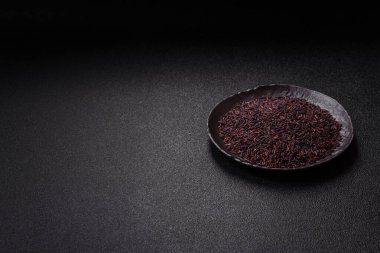 Seramik bir kasede kırmızı veya kahverengi çiğ pirinç. Pirinç Asya organik gıdasının bir malzemesidir.