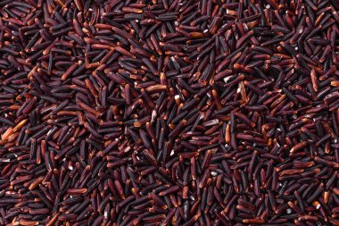 Seramik bir kasede kırmızı veya kahverengi çiğ pirinç. Pirinç Asya organik gıdasının bir malzemesidir.