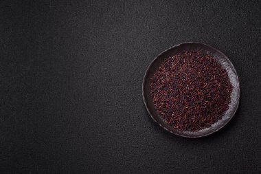 Seramik bir kasede kırmızı veya kahverengi çiğ pirinç. Pirinç Asya organik gıdasının bir malzemesidir.