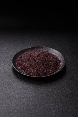 Seramik bir kasede kırmızı veya kahverengi çiğ pirinç. Pirinç Asya organik gıdasının bir malzemesidir.