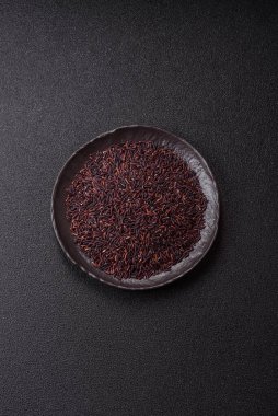 Seramik bir kasede kırmızı veya kahverengi çiğ pirinç. Pirinç Asya organik gıdasının bir malzemesidir.