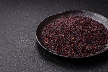 Seramik bir kasede kırmızı veya kahverengi çiğ pirinç. Pirinç Asya organik gıdasının bir malzemesidir.