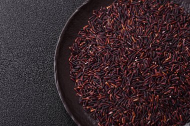 Seramik bir kasede kırmızı veya kahverengi çiğ pirinç. Pirinç Asya organik gıdasının bir malzemesidir.