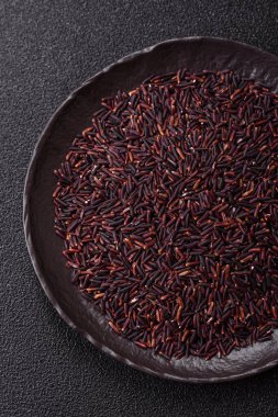 Seramik bir kasede kırmızı veya kahverengi çiğ pirinç. Pirinç Asya organik gıdasının bir malzemesidir.