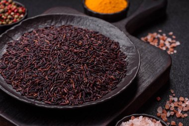 Seramik bir kasede kırmızı veya kahverengi çiğ pirinç. Pirinç Asya organik gıdasının bir malzemesidir.