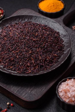 Seramik bir kasede kırmızı veya kahverengi çiğ pirinç. Pirinç Asya organik gıdasının bir malzemesidir.