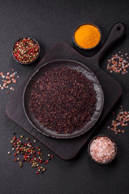 Seramik bir kasede kırmızı veya kahverengi çiğ pirinç. Pirinç Asya organik gıdasının bir malzemesidir.