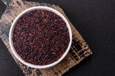 Seramik bir kasede kırmızı veya kahverengi çiğ pirinç. Pirinç Asya organik gıdasının bir malzemesidir.