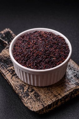 Seramik bir kasede kırmızı veya kahverengi çiğ pirinç. Pirinç Asya organik gıdasının bir malzemesidir.