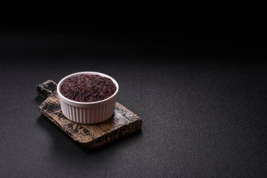 Seramik bir kasede kırmızı veya kahverengi çiğ pirinç. Pirinç Asya organik gıdasının bir malzemesidir.