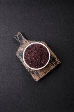 Seramik bir kasede kırmızı veya kahverengi çiğ pirinç. Pirinç Asya organik gıdasının bir malzemesidir.