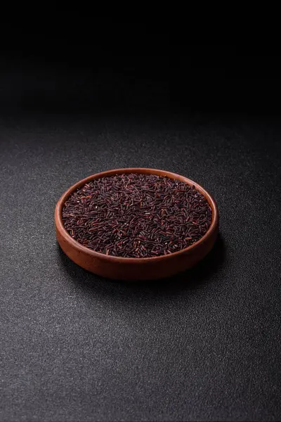 Seramik bir kasede kırmızı veya kahverengi çiğ pirinç. Pirinç Asya organik gıdasının bir malzemesidir.