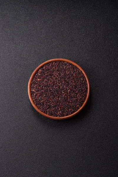 Seramik bir kasede kırmızı veya kahverengi çiğ pirinç. Pirinç Asya organik gıdasının bir malzemesidir.