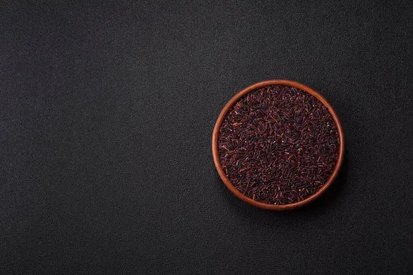 Seramik bir kasede kırmızı veya kahverengi çiğ pirinç. Pirinç Asya organik gıdasının bir malzemesidir.