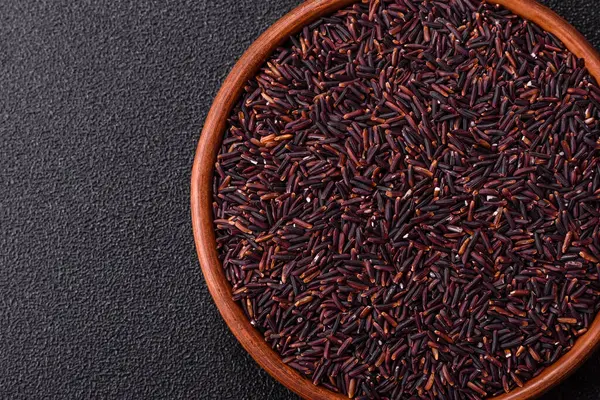 Seramik bir kasede kırmızı veya kahverengi çiğ pirinç. Pirinç Asya organik gıdasının bir malzemesidir.