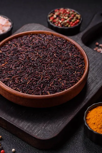 Seramik bir kasede kırmızı veya kahverengi çiğ pirinç. Pirinç Asya organik gıdasının bir malzemesidir.