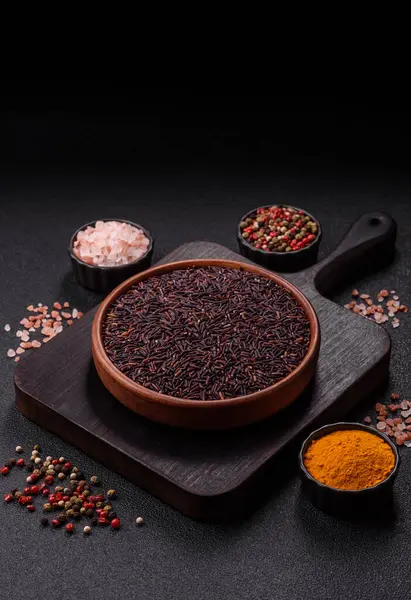 Seramik bir kasede kırmızı veya kahverengi çiğ pirinç. Pirinç Asya organik gıdasının bir malzemesidir.