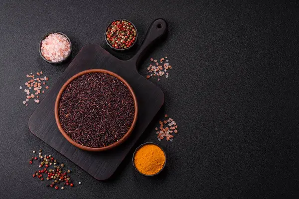 Seramik bir kasede kırmızı veya kahverengi çiğ pirinç. Pirinç Asya organik gıdasının bir malzemesidir.