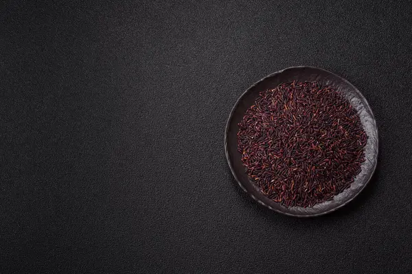 Seramik bir kasede kırmızı veya kahverengi çiğ pirinç. Pirinç Asya organik gıdasının bir malzemesidir.