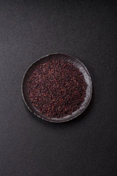 Seramik bir kasede kırmızı veya kahverengi çiğ pirinç. Pirinç Asya organik gıdasının bir malzemesidir.