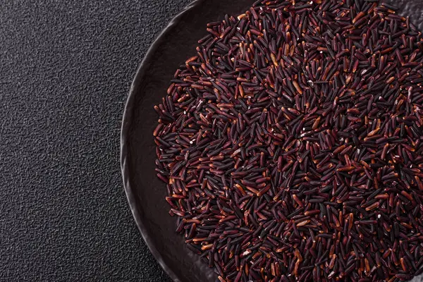 Seramik bir kasede kırmızı veya kahverengi çiğ pirinç. Pirinç Asya organik gıdasının bir malzemesidir.