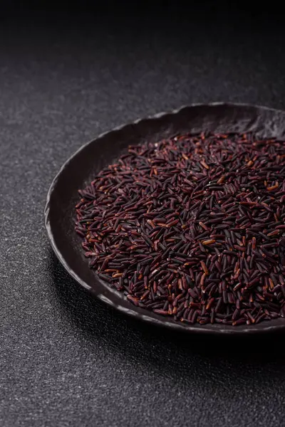 Seramik bir kasede kırmızı veya kahverengi çiğ pirinç. Pirinç Asya organik gıdasının bir malzemesidir.