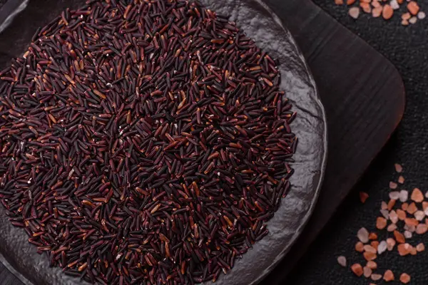 Seramik bir kasede kırmızı veya kahverengi çiğ pirinç. Pirinç Asya organik gıdasının bir malzemesidir.