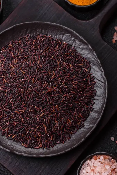 Seramik bir kasede kırmızı veya kahverengi çiğ pirinç. Pirinç Asya organik gıdasının bir malzemesidir.