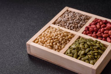 Organik sağlıklı yiyecekler için bir kutu fıstık, sedir fıstığı, ayçiçeği ve balkabağı çekirdeği.