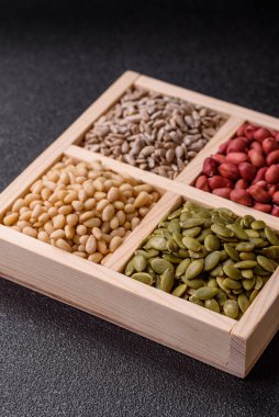 Organik sağlıklı yiyecekler için bir kutu fıstık, sedir fıstığı, ayçiçeği ve balkabağı çekirdeği.