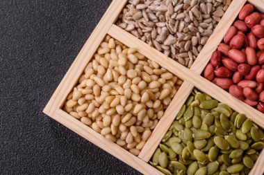 Organik sağlıklı yiyecekler için bir kutu fıstık, sedir fıstığı, ayçiçeği ve balkabağı çekirdeği.