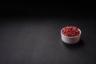 Koyu beton arka planda bir kasede yer fıstığı ya da kabuğu soyulmuş graundnut. Protein kaynağı olarak fındık