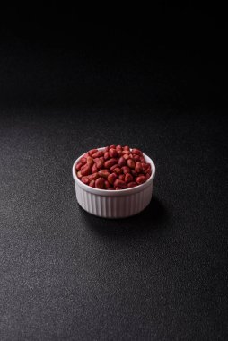 Koyu beton arka planda bir kasede yer fıstığı ya da kabuğu soyulmuş graundnut. Protein kaynağı olarak fındık
