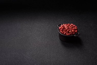 Koyu beton arka planda bir kasede yer fıstığı ya da kabuğu soyulmuş graundnut. Protein kaynağı olarak fındık