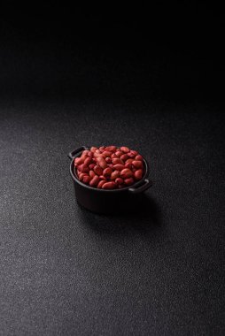 Koyu beton arka planda bir kasede yer fıstığı ya da kabuğu soyulmuş graundnut. Protein kaynağı olarak fındık