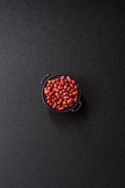 Koyu beton arka planda bir kasede yer fıstığı ya da kabuğu soyulmuş graundnut. Protein kaynağı olarak fındık