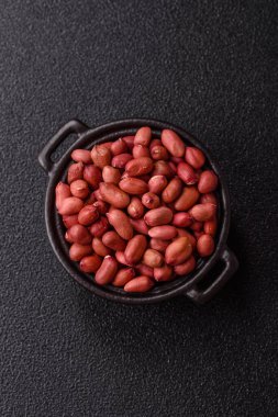 Koyu beton arka planda bir kasede yer fıstığı ya da kabuğu soyulmuş graundnut. Protein kaynağı olarak fındık