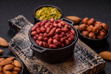 Koyu beton arka planda bir kasede yer fıstığı ya da kabuğu soyulmuş graundnut. Protein kaynağı olarak fındık