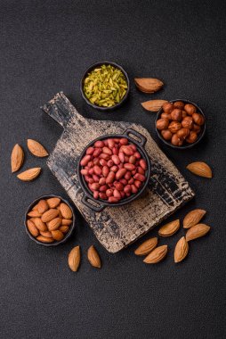 Koyu beton arka planda bir kasede yer fıstığı ya da kabuğu soyulmuş graundnut. Protein kaynağı olarak fındık