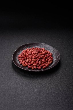 Koyu beton arka planda bir kasede yer fıstığı ya da kabuğu soyulmuş graundnut. Protein kaynağı olarak fındık