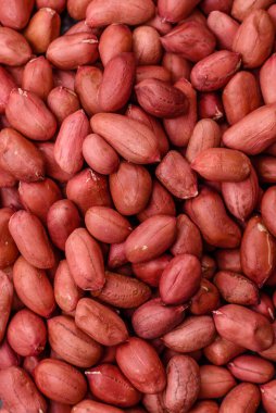 Koyu beton arka planda bir kasede yer fıstığı ya da kabuğu soyulmuş graundnut. Protein kaynağı olarak fındık