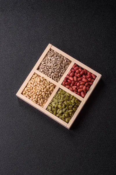 Organik sağlıklı yiyecekler için bir kutu fıstık, sedir fıstığı, ayçiçeği ve balkabağı çekirdeği.