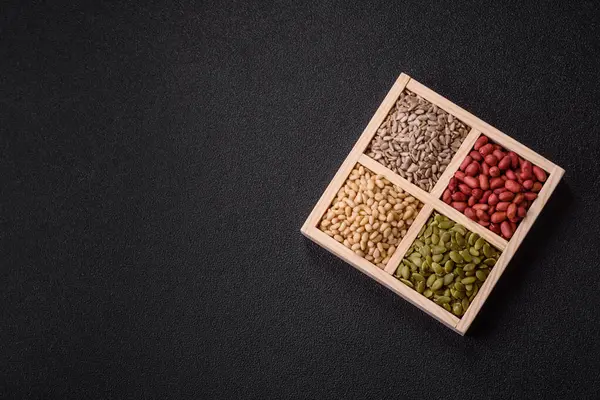 Organik sağlıklı yiyecekler için bir kutu fıstık, sedir fıstığı, ayçiçeği ve balkabağı çekirdeği.